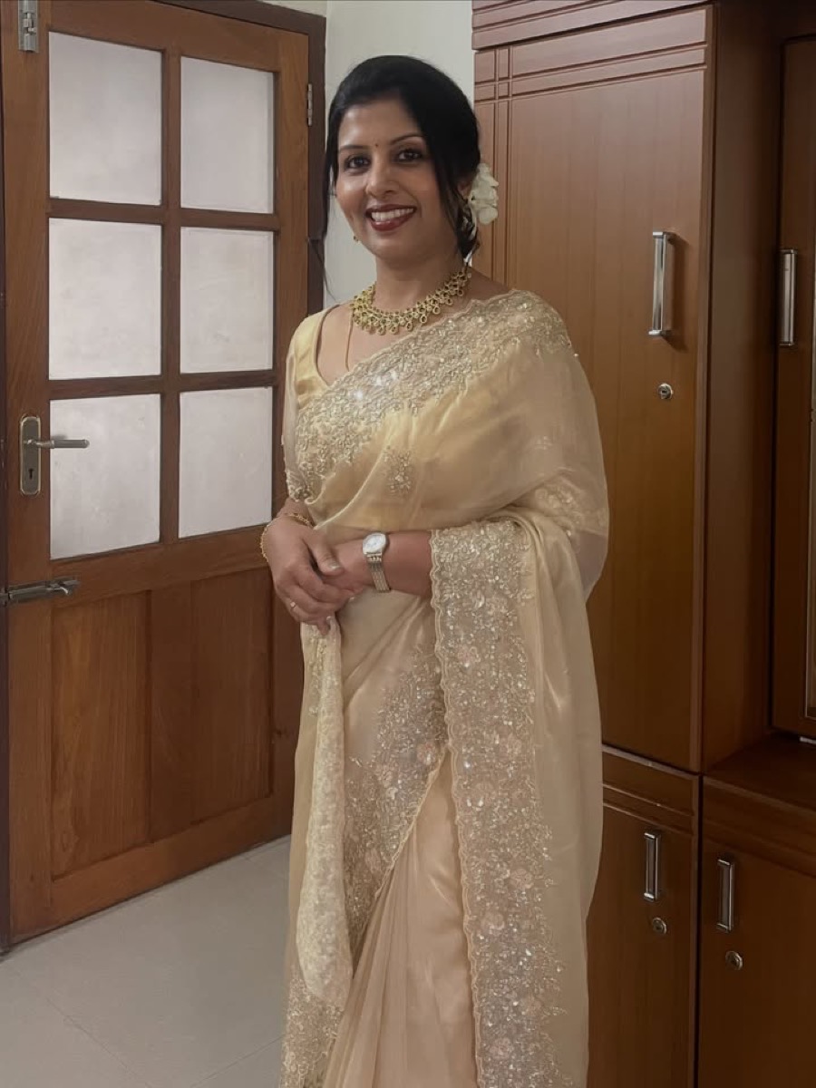 A client in an embroidered cream saree
