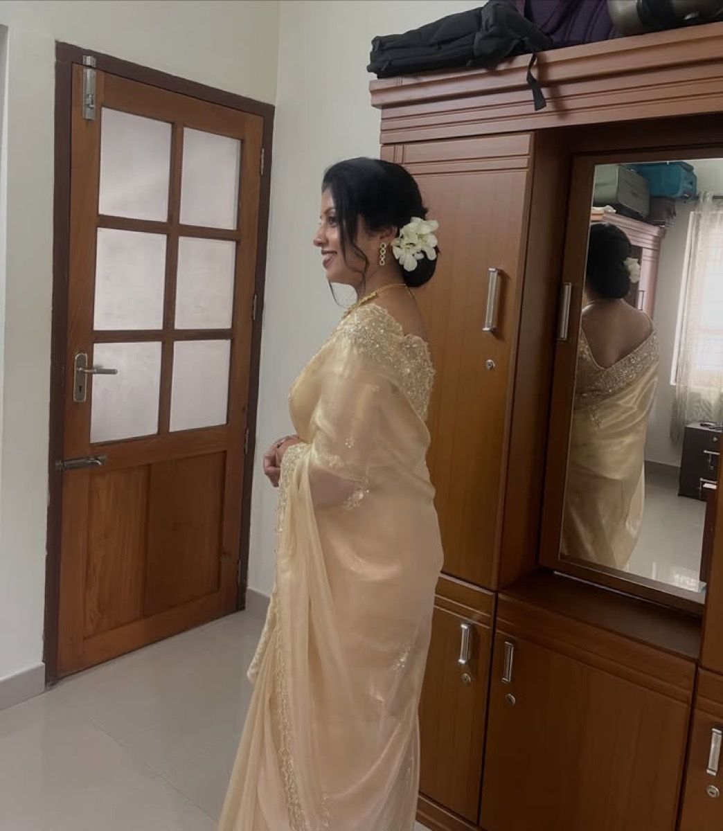 Back view of a bun with white flowers and a cream saree