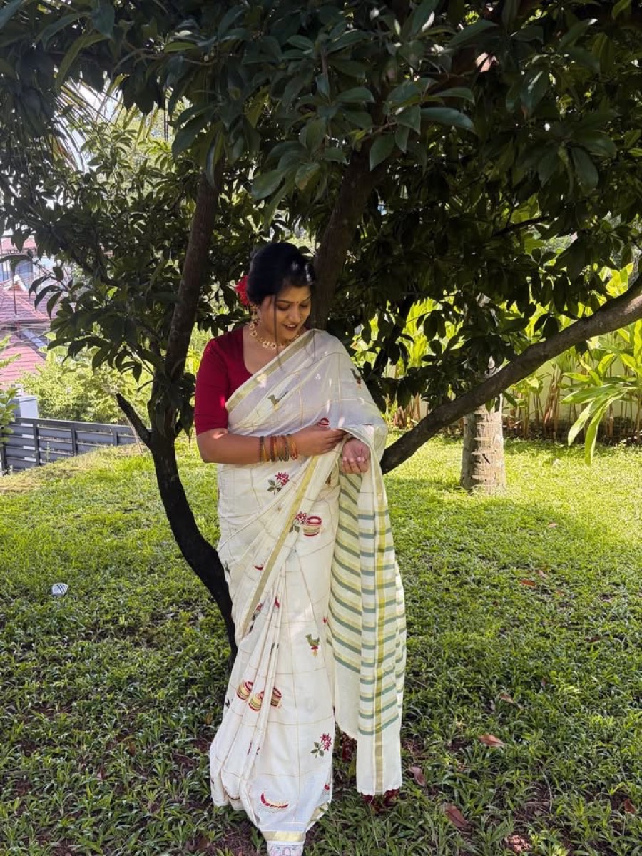 A client in a white printed saree with a red blouse