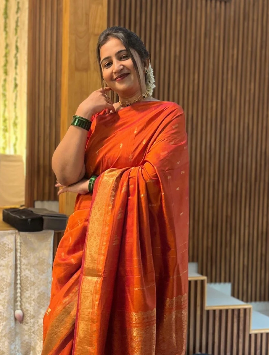 A candid photo of a client in an orange and gold saree