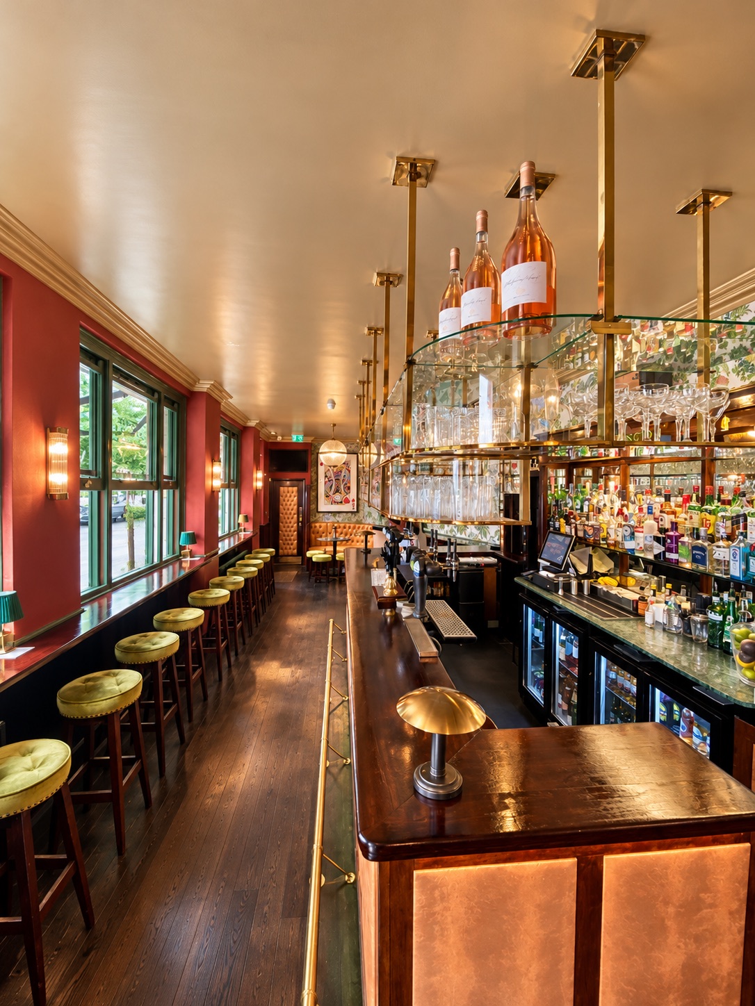 The long brass bar with stools and hanging glassware