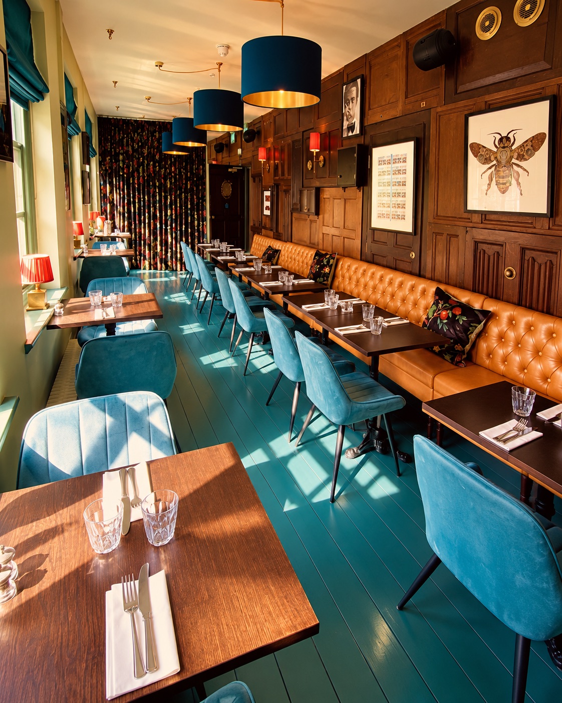 The upstairs dining room with teal chairs and leather banquettes
