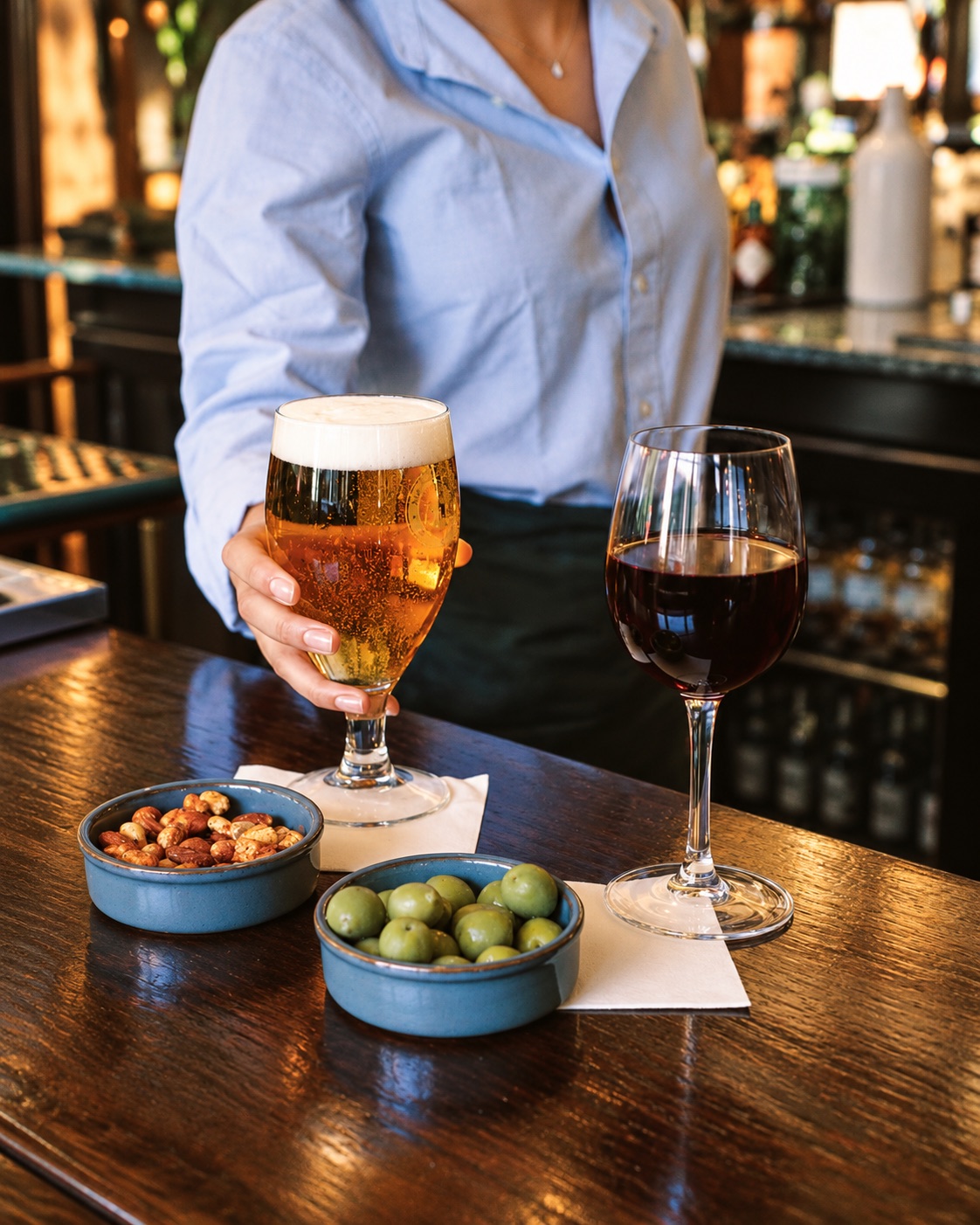 A pint and a glass of red wine with bar snacks