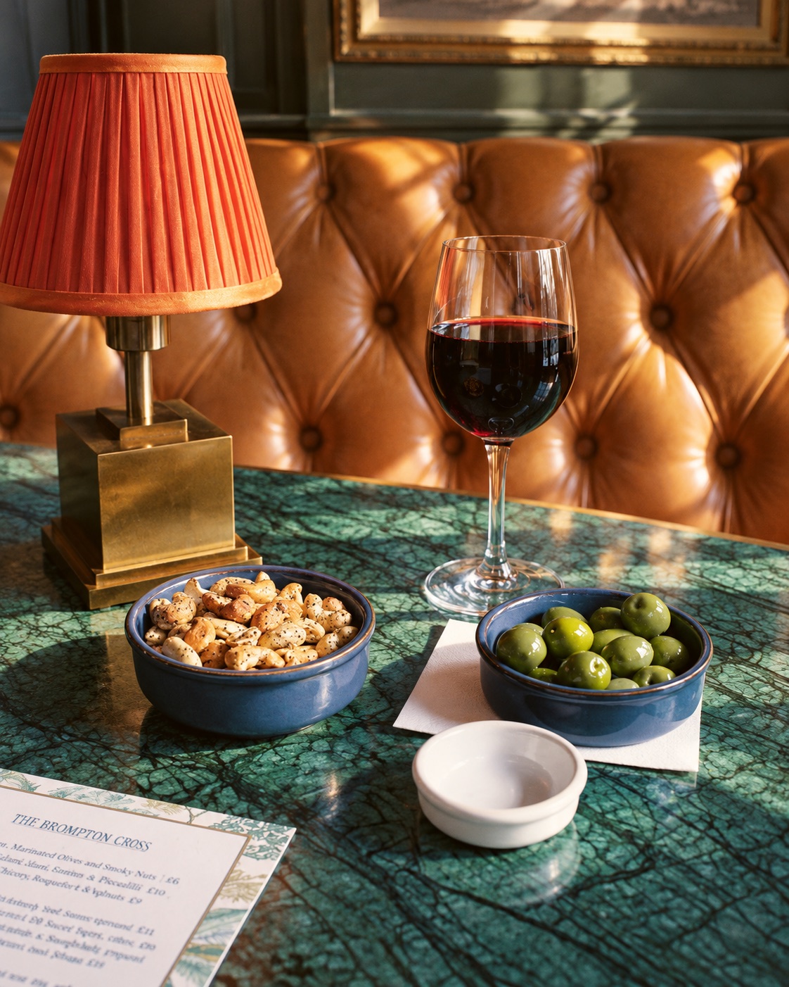 Red wine, olives and nuts on a marble table